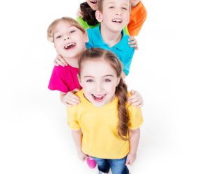 Group of happy children in colorful t-shirts standing together. Top view. Isolated on white.